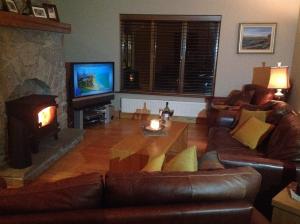 ein Wohnzimmer mit einem Sofa und einem Kamin in der Unterkunft 4 bedroom holiday home overlooking the sea in Connemara in Rossaveel