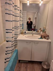 une femme prenant une photo dans un miroir de salle de bains dans l'établissement Chambre chez l'habitant quartier résidentiel, à Avignon