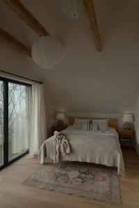 Un dormitorio con una cama y una ventana grande. en Cozy Izeria, en Grudza