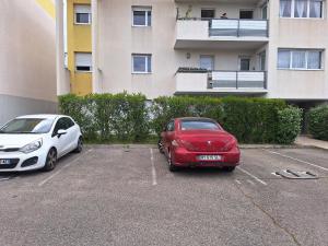 2 voitures garées sur un parking en face d'un immeuble dans l'établissement Chambre chez l'habitant quartier résidentiel, à Avignon