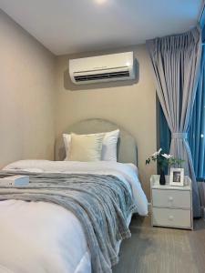 a bedroom with a large bed and a air conditioner at Metro sky prachachuen in Bang Su
