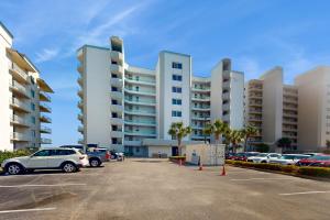 un aparcamiento con coches estacionados frente a grandes edificios en Silver Beach 205 en Orange Beach