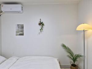 una camera bianca con letto e lampada di Iceblue stay a Seul