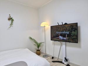 una camera da letto con TV a schermo piatto a parete di Iceblue stay a Seul