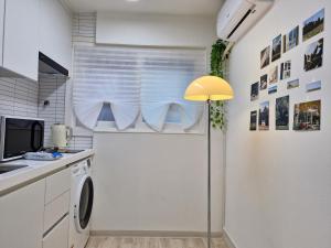 una cucina con lavatrice e lampada gialla di Iceblue stay a Seul