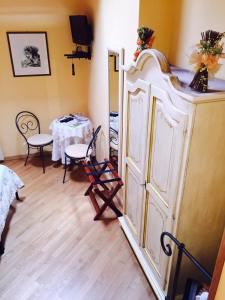 una stanza con tavolo, sedie e armadietto bianco di Il Timone Lerta a Monterosso al Mare