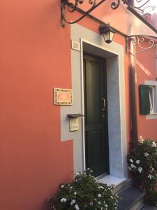 an orange building with a door and some flowers at Il Timone Lerta in Monterosso al Mare