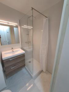 Un baño con ducha de cristal y lavabo. en Résidence La Palme d'Azur - Petersen App 610, en Cannes