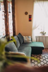 a living room with a green couch and a window at Family apartment in Riga center Free parking in Rīga