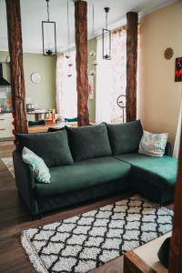 a green couch sitting in a living room at Family apartment in Riga center Free parking in Rīga