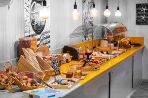 ein Buffet mit Brot und Gebäck auf dem Tisch in der Unterkunft The Originals City, Hôtel L'Hippocampe, Sète Balaruc-le-Vieux in Balaruc-le-Vieux