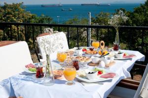 Queen Seagull Boutique Hotel في إسطنبول: طاولة مع الطعام والمشروبات على شرفة مع المحيط