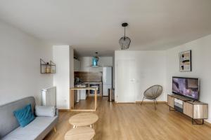 een woonkamer met een bank en een tafel bij Chic and spacious apart southern Paris in Massy