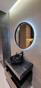 巴庫的住宿－Baku White City-Seaview Luxury Apartment，浴室设有黑色水槽和镜子