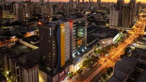 eine Aussicht über eine Stadt in der Nacht in der Unterkunft HUS Hotel MARINGA in Maringá