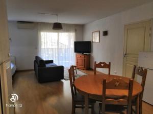 a living room with a table and a couch at Grand studio à la montagne in Ax-les-Thermes