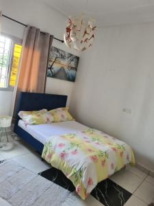 Schlafzimmer mit einem Bett und einem Kronleuchter in der Unterkunft Elyam's Home 2 in Douala