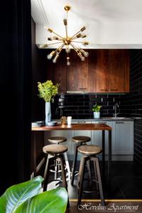 a kitchen with a bar with stools and a ceiling fan at Bayside Apartments in Gdańsk