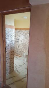 baño con aseo y suelo de baldosa. en KASBAH ALTAÏR en El Kelaa des Mgouna