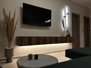 a living room with a flat screen tv on the wall at Caruso Central Apartments in Lefkada