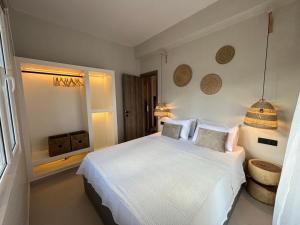 a bedroom with a white bed and a window at Caruso Central Apartments in Lefkada