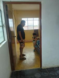 un hombre parado en una puerta con un niño en una habitación en Casas Cueva, en Tumbes