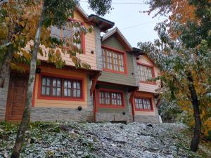 a house with red and orange trim at Cabañas Buena Vista Rosi in San Carlos de Bariloche