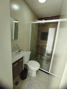 uma casa de banho com um WC, um lavatório e um chuveiro em Suítes Do Forno em Arraial do Cabo