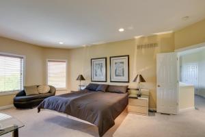 a bedroom with a large bed and a chair at Spacious Missouri Retreat with Pool, Gym and Game Room in Chesterfield