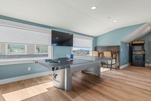 a gaming room with a ping pong table in it at Island Enchantment by KEES Vacations in Kill Devil Hills +186 photos
