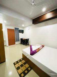 a room with a bed and a dining room at Drizzle Valley Cottage in Munnar