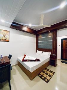 a bedroom with a bed and a desk and a table at Drizzle Valley Cottage in Munnar