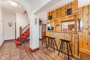 a bar in a room with wooden walls and stools at Logan Lodge, Great Yarmouth - for your large group! in Great Yarmouth