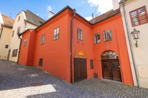 un bâtiment orange avec une porte et une rue dans l'établissement Church Apartments, à Český Krumlov