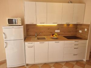eine Küche mit einem weißen Kühlschrank und einer Schale mit Obst in der Unterkunft Studio für 5 Personen ca 70 qm in Crikvenica, Kvarner Bucht Crikvenica und Umgebung in Crikvenica