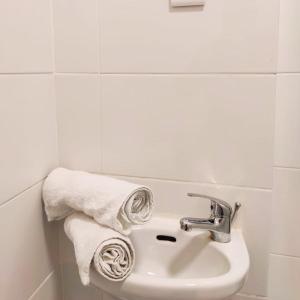 a bathroom with a sink and towels on a wall at Liberdade Home Royal direito in Braga