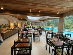 um restaurante com mesas e cadeiras e uma piscina em Recanto de Moriá em Penedo