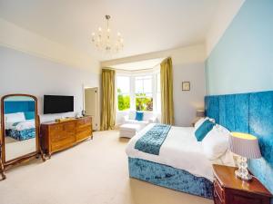 um quarto com uma cama grande e uma televisão em Crofton House Hotel em Torquay