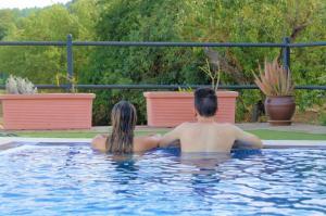 a man and woman sitting in a swimming pool at Gemütliches Ferienhaus in El Rosario mit Privatem Pool und Panoramablick in El Rosario