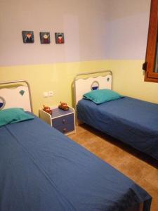 1 dormitorio con 2 camas y mesita de noche en Family friendly house nearby the sea, en Agia Paraskevi