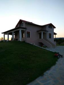 una casa sentada en la cima de un exuberante campo verde en Family friendly house nearby the sea, en Agia Paraskevi