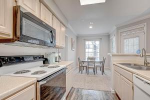 a kitchen with a stove and a sink and a table at Central Houston- Urban Living in Houston