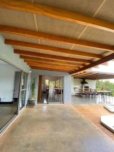 uma grande sala de estar com um grande tecto de madeira em Casa com vista para as montanhas em Atibaia