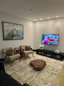 uma sala de estar com sofás e uma televisão de ecrã plano em Casa com vista para as montanhas em Atibaia