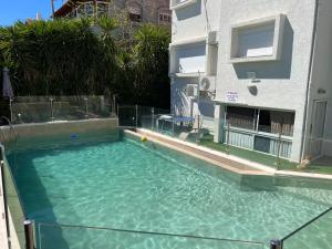 une grande piscine en face d'un bâtiment dans l'établissement אחוזת רוממה - Villa Romema, à Safed