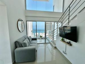 a living room with a couch and a flat screen tv at Luxury Sea View Duplex in the Heart of the City in Cartagena de Indias