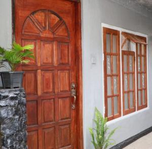 a wooden door of a house with a window at Green Heart Homestay in Nuwara Eliya