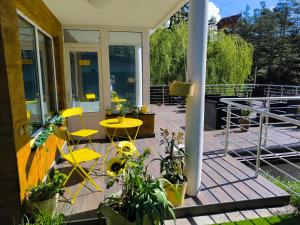 un patio con sillas amarillas, una mesa y algunas plantas en Vila POGLED Wellness i spa en Divčibare
