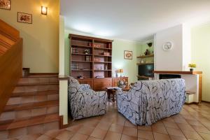 ein Wohnzimmer mit 2 Stühlen und einem Bücherregal in der Unterkunft Villa Mirarino in Raffa