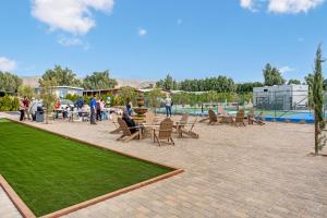 a group of people sitting around a patio with grass at RV71-Lot- Paradise RV Park in Desert Hot Springs